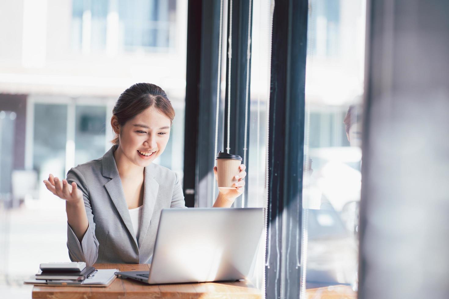 Young asian woman confident working at home with laptop computer and thinking idea for planning, freelance happy girl excited and success using notebook thoughtful and writing, business concept. photo