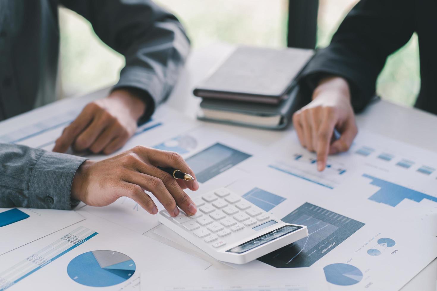 Two business people discuss meeting targets sitting at the business table with documents photo