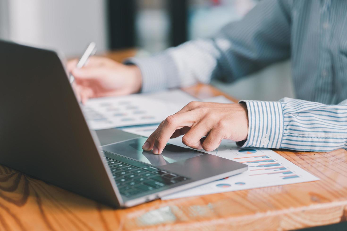 Business hand pressing on the laptop keyboard, World of technology and internet communication, Financial professionals use laptop to calculate and check real estate earnings. photo