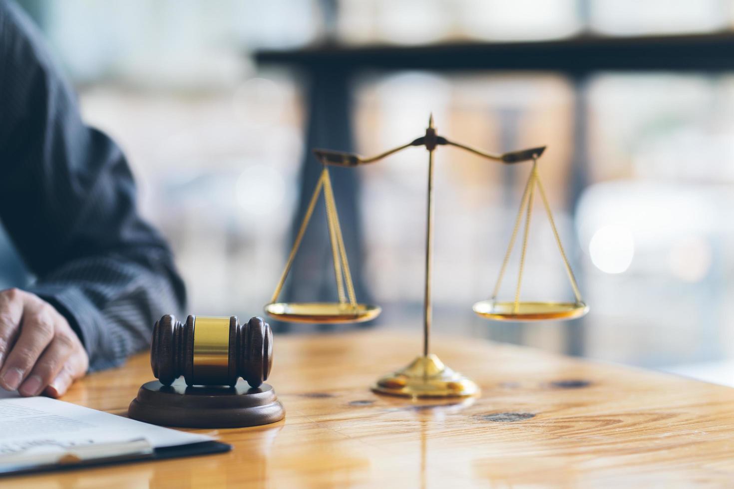 Business and lawyers discussing contract papers with brass scale on desk in office. Law, legal services, advice, justice and law concept. photo