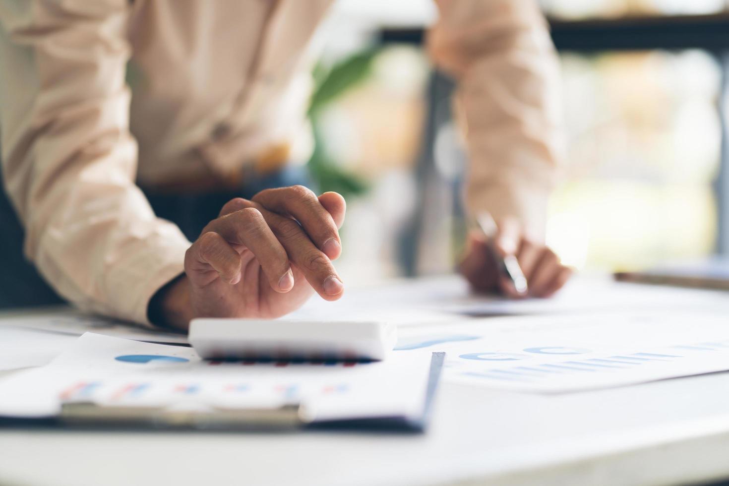 businessman working on desk office with using a calculator to calculate the numbers, finance accounting concept photo