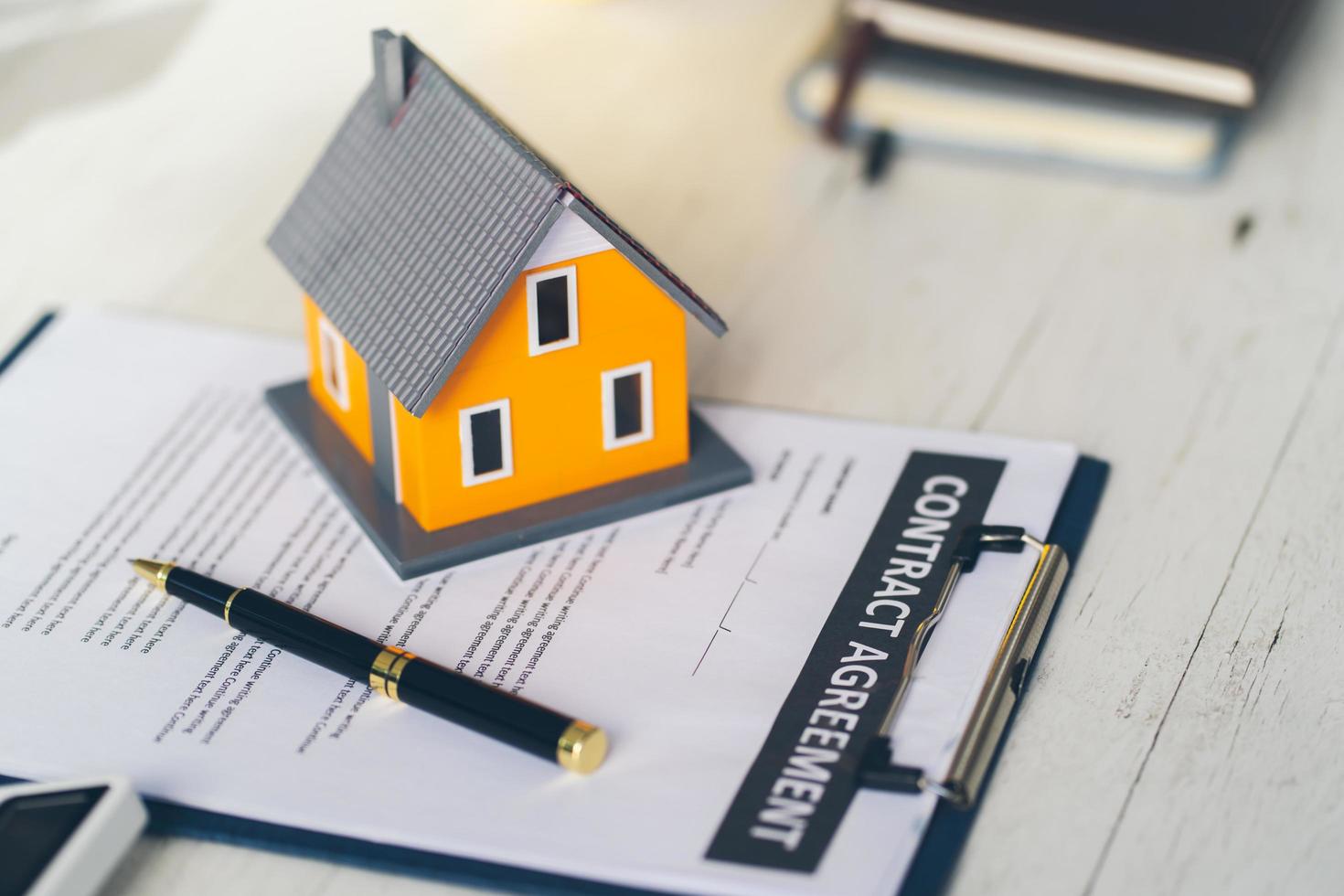A model house placed on the house purchase contract Real estate ideas, buying a home, landlord, renting a mortgage, buy a home for the future. photo