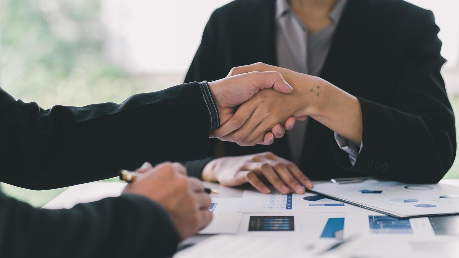 Two confident business man shaking hands during a meeting in the office, success, dealing, greeting and partner concept. photo