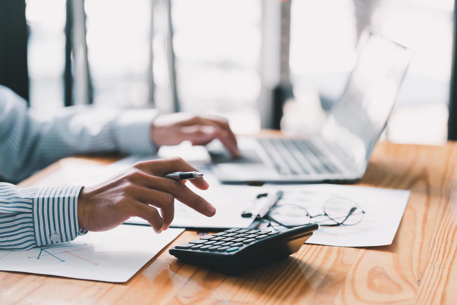 Accounting businessman are calculating income expenditure and analyzing real estate investment data, Dedicated to the progress and growth of the company, Financial and tax systems concept. photo