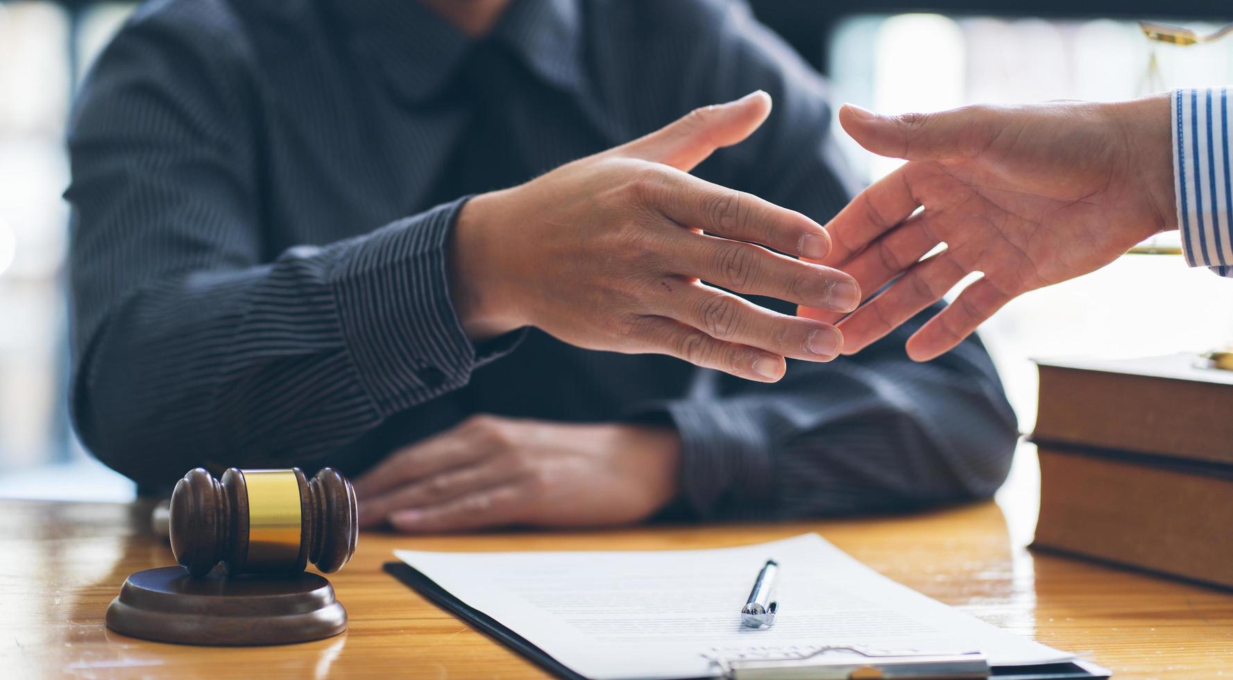 Good service cooperation of Consultation between a male lawyer and business woman customer, Handshake after good deal agreement, Law and Legal concept. photo