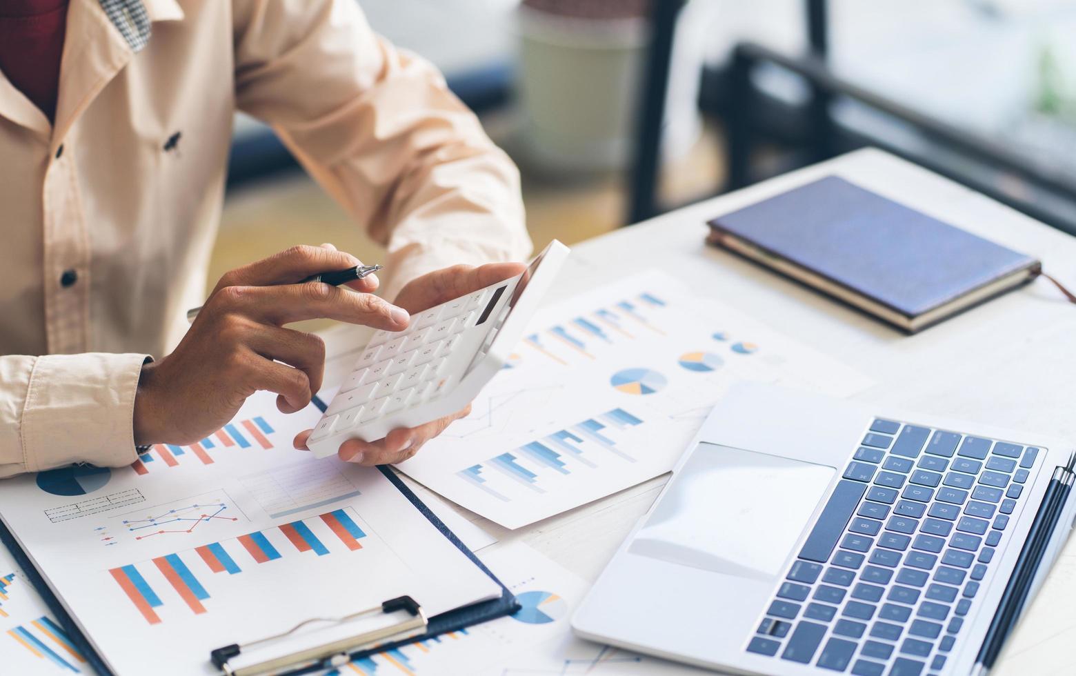 businessman working on desk office with using a calculator to calculate the numbers, finance accounting concept photo