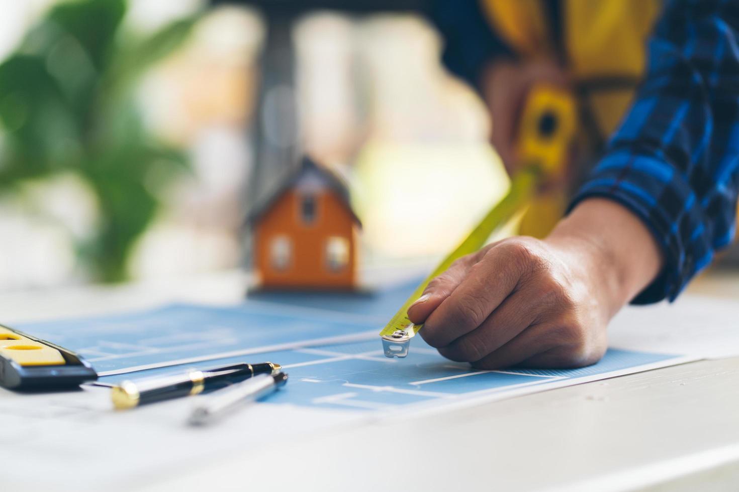 arquitecto o ingeniero que trabaja en la oficina con planos, inspección de ingenieros en el lugar de trabajo para el plan arquitectónico, esbozo de un proyecto de construcción, concepto de construcción empresarial. foto