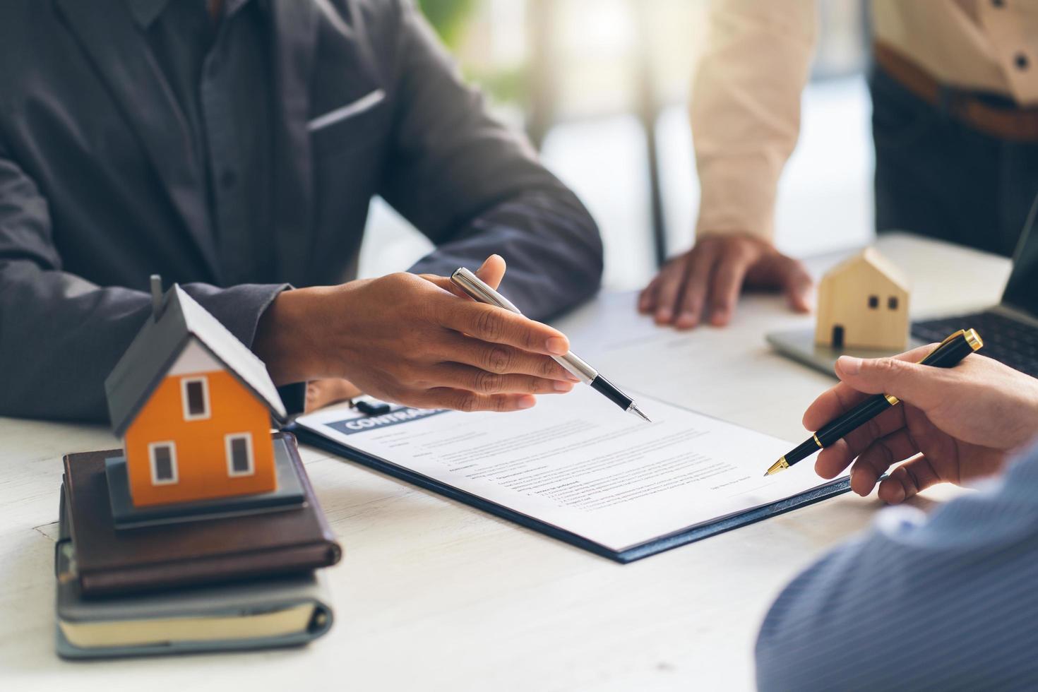 Real estate agent talked about the terms of the home purchase agreement and asked the customer to sign the documents to make the contract legally, Home sales and home insurance concept. photo