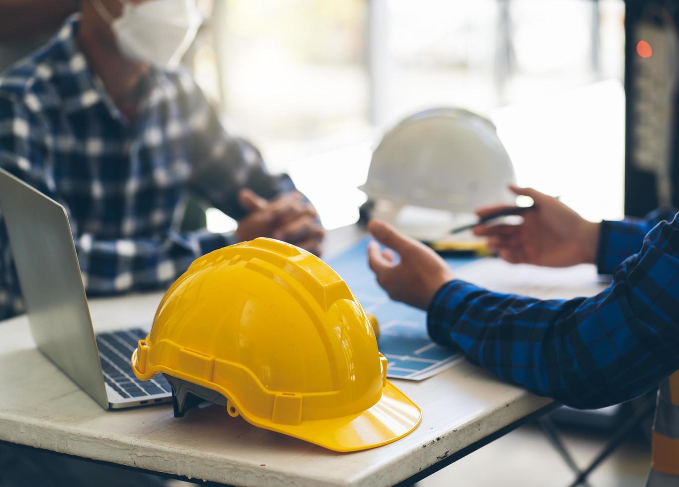 reunión de trabajo en equipo de ingenieros, trabajo de dibujo en la reunión de planos para el trabajo del proyecto con un socio en la construcción de modelos y herramientas de ingeniería en el concepto de sitio de trabajo, construcción y estructura. foto