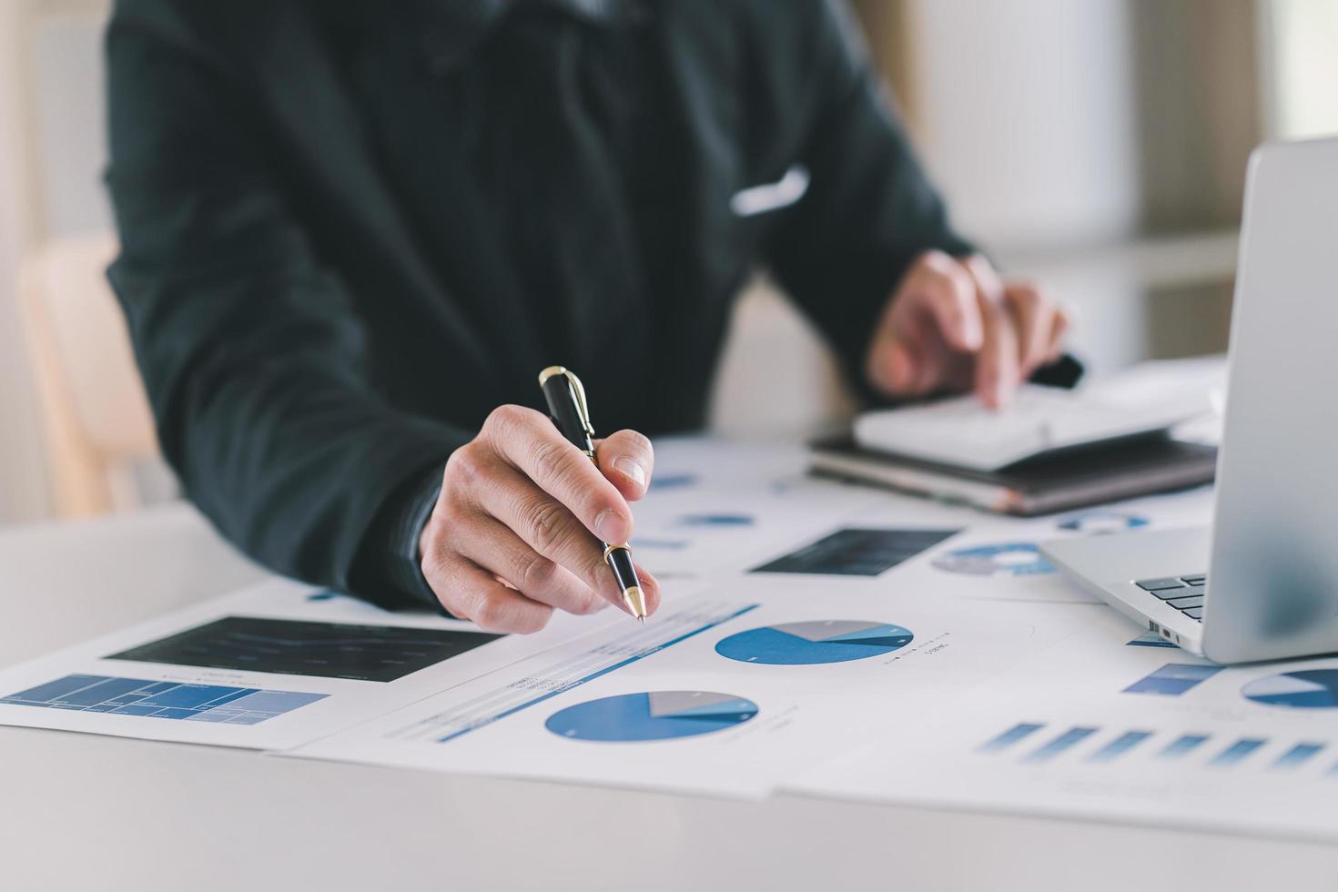 Close up Businessman using calculator and laptop for calaulating finance, tax, accounting, statistics and analytic research concept photo