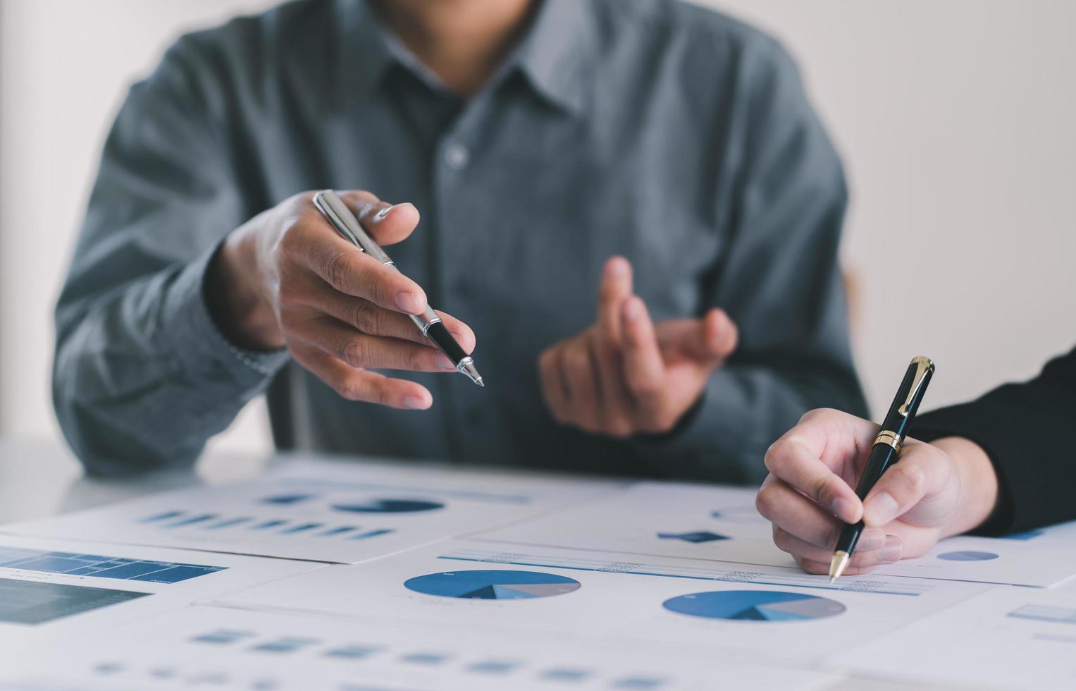 Image of two young business team writting notebook and graph financia at meeting.Close up business team analysis and strategy concept. photo