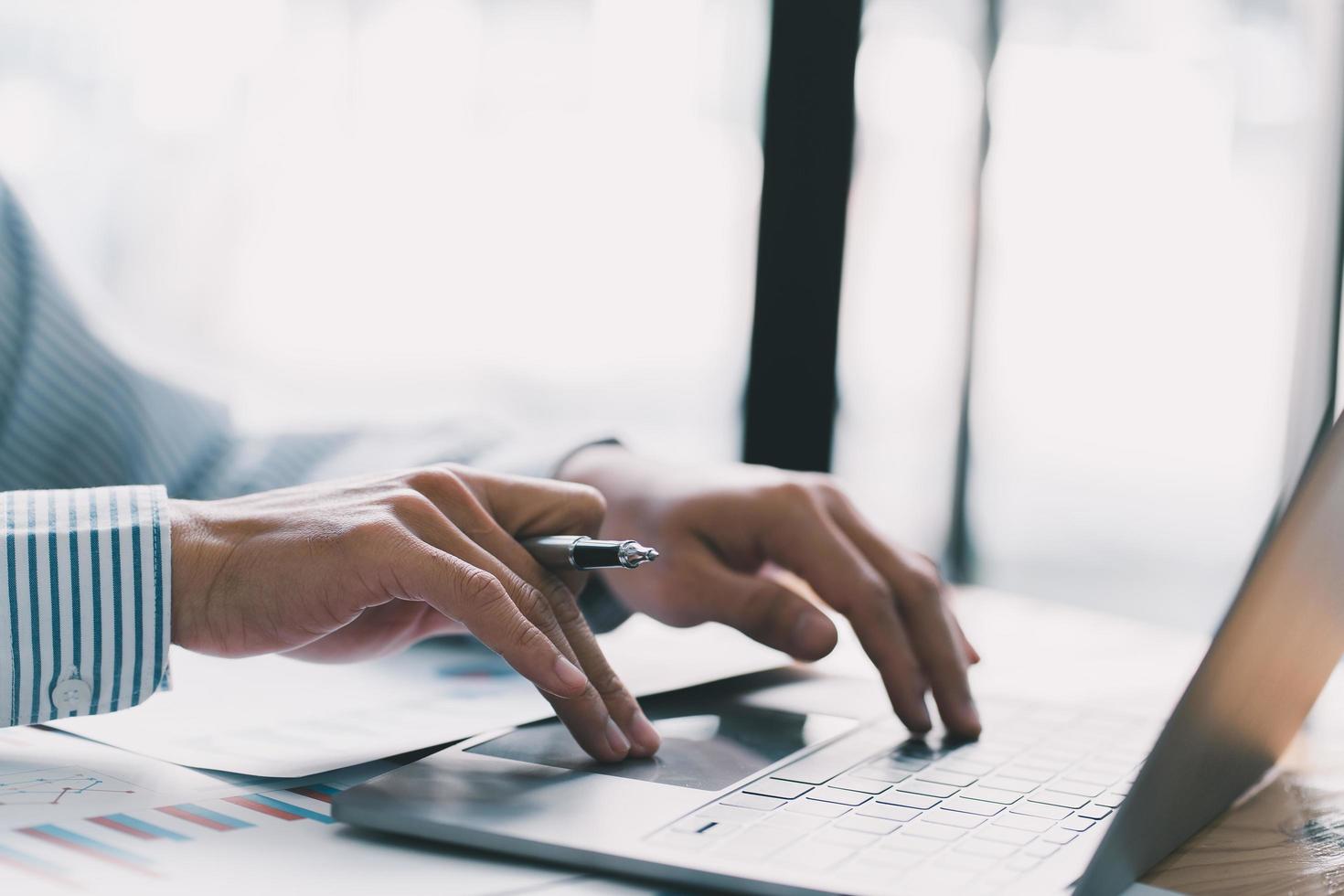 el hombre de negocios presiona el teclado de la computadora portátil, el mundo de la tecnología y la comunicación por Internet, los profesionales financieros usan la computadora portátil para calcular y verificar las ganancias de bienes raíces. foto