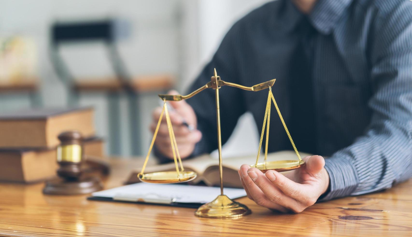 Male lawyer or judge working with contract papers, Law books and wooden gavel on table in courtroom, Justice lawyers at law firm, Law and Legal services concept. photo