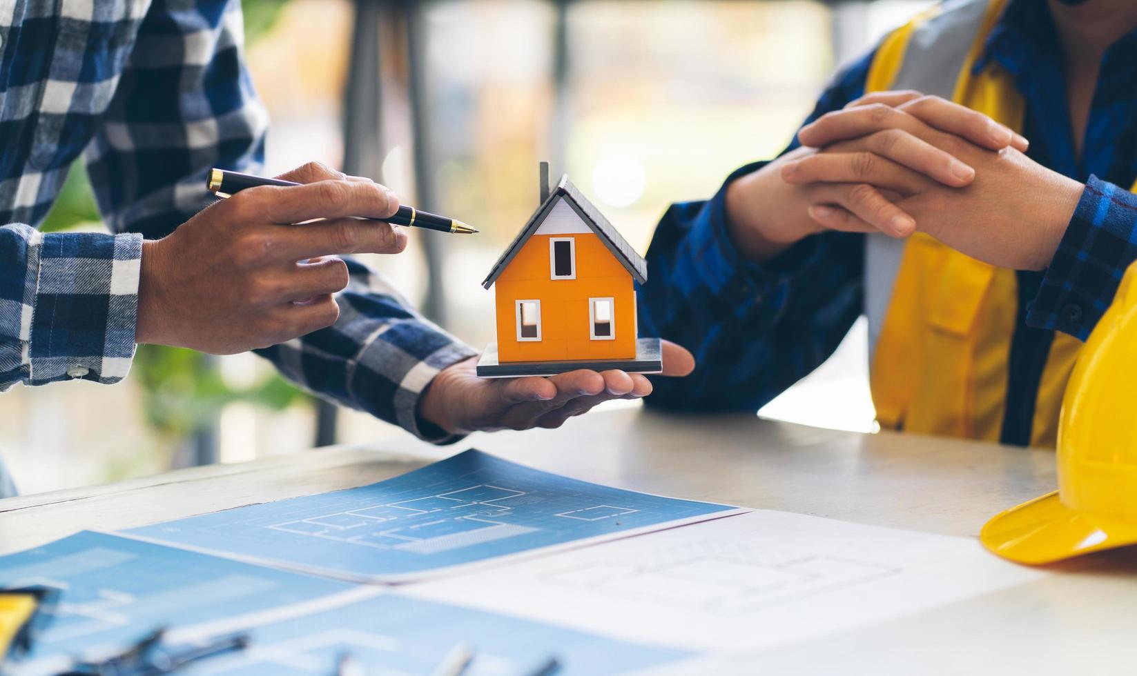 planificación de reuniones de arquitecto e ingeniero para un nuevo proyecto con equipos de construcción en la mesa, arquitecto e ingeniero trabajando con planos y modelos de casas. foto