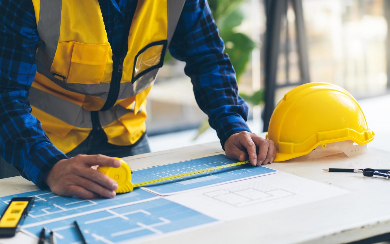 Architect and engineer meeting Planning for a New Project with construction equipment on table, Architect and engineer working with blueprint. photo