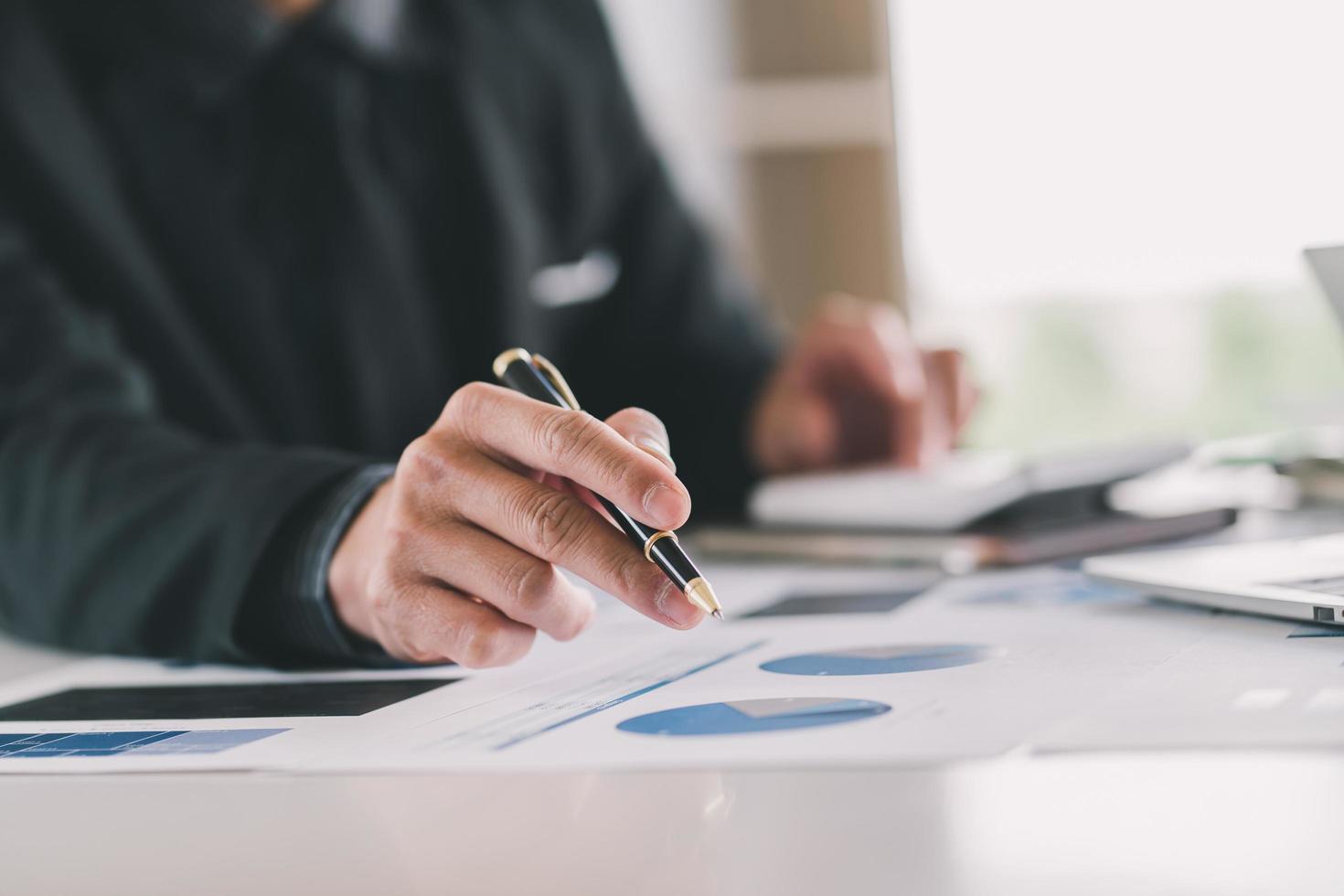 Close up Businessman using calculator and laptop for calaulating finance, tax, accounting, statistics and analytic research concept photo