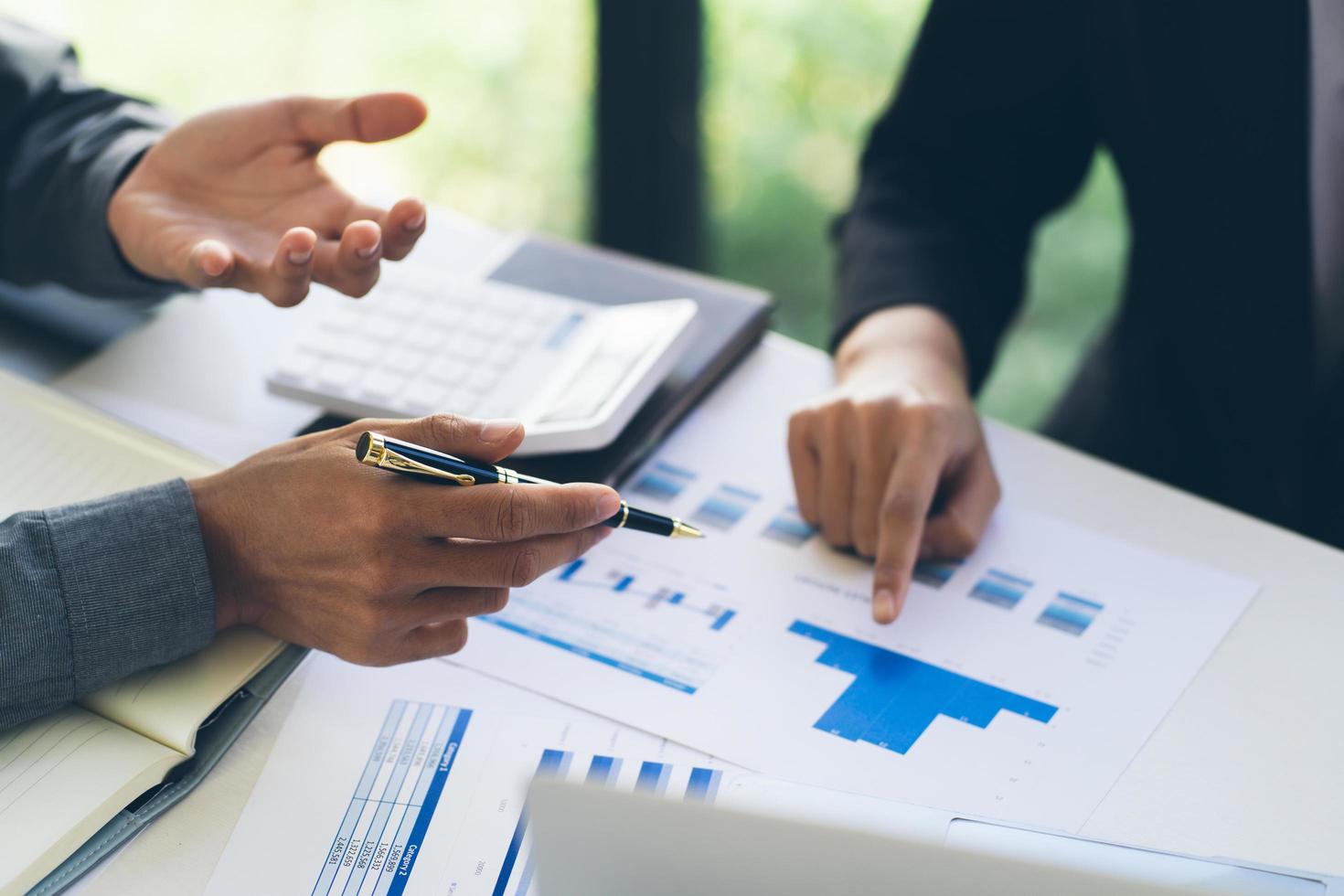 Two colleagues discussing data with document data on desk table. Close up business people meeting to discuss the situation on the market. photo