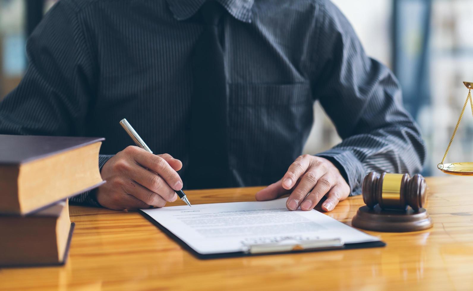 Business and lawyers discussing contract papers with brass scale on desk in office. Law, legal services, advice, justice and law concept. photo