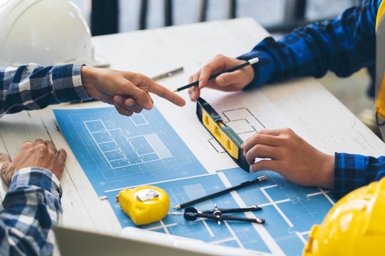 reunión de ingenieros y arquitectos trabajando y señalando dibujos en la oficina para discutir. herramientas de ingeniería y concepto de construcción, ingenieros y arquitectos hacen una lluvia de ideas. foto