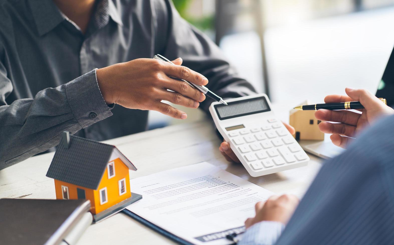 House model with agent and customer discussing for contract to buy, get insurance or loan real estate or property. photo