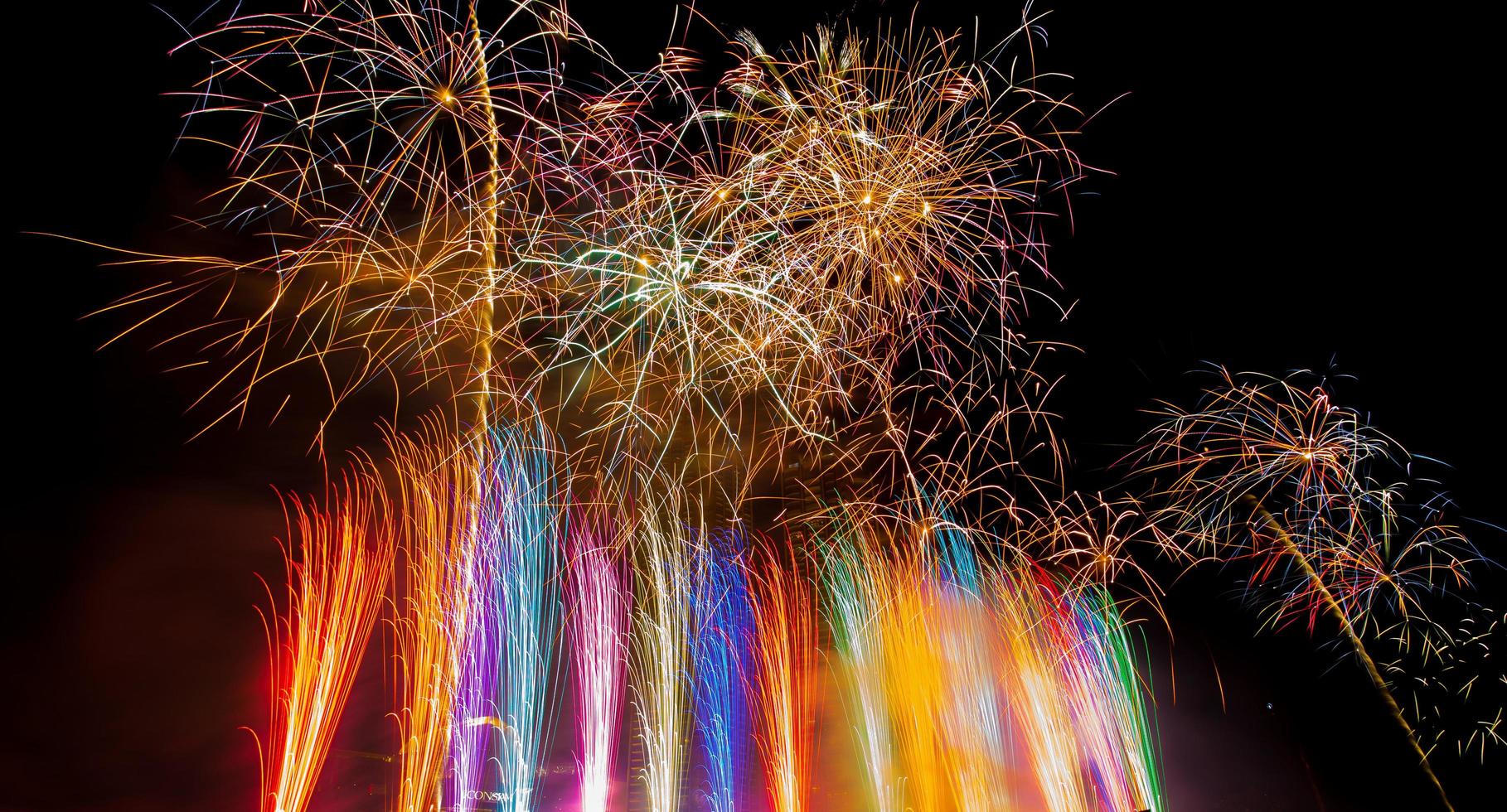 colorido espectáculo de fuegos artificiales de año nuevo que ilumina el cielo nocturno en chao phraya rive foto