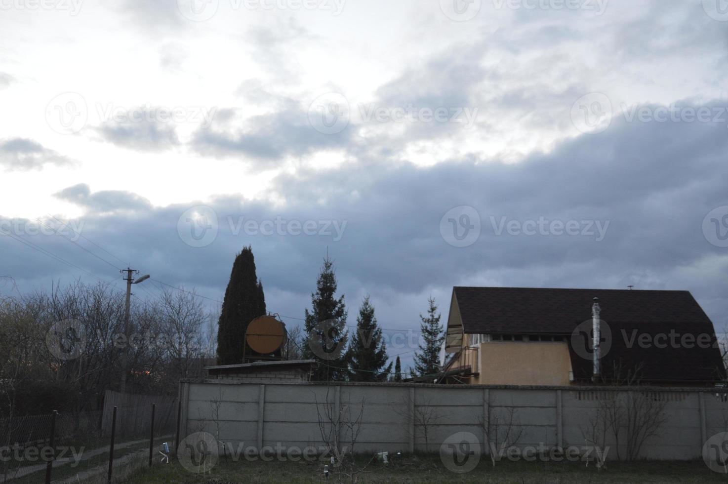 Thunderclouds in the evening on the sky in the village photo