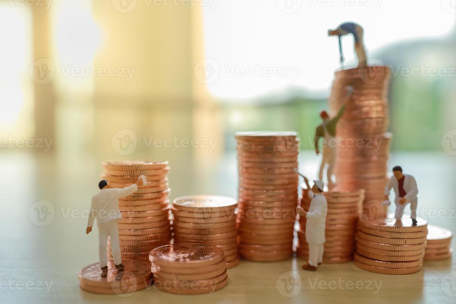 Business, Money, Planning and Saving Concept. Close up of group of worker cleaning and painting stack of coin. photo