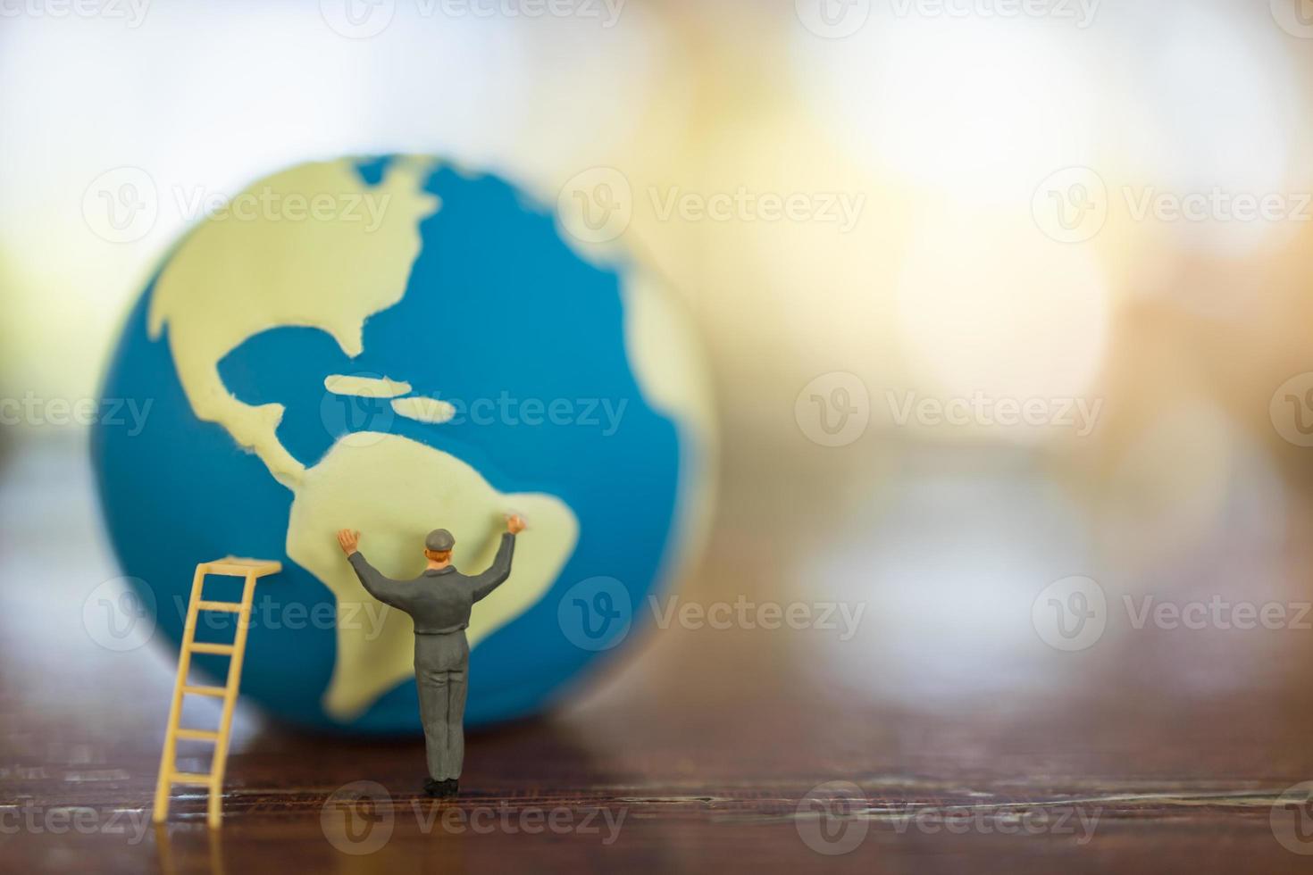 Save Global Environment Care Concept. Close up of worker miniature people with ladder cleaning mini world ball on white table with copy space. photo