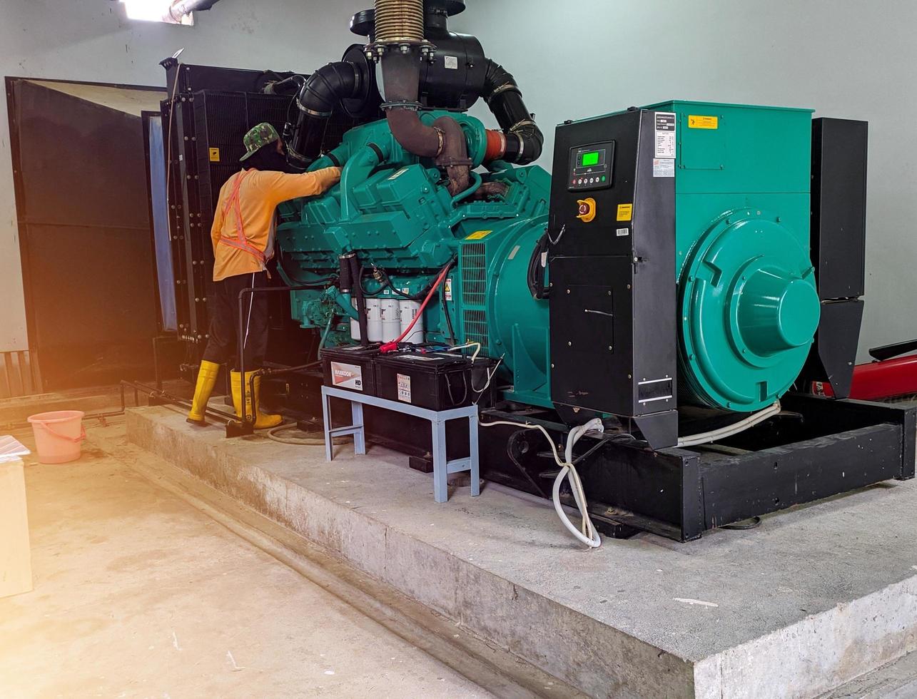 .a technician is doing regular maintenance on the generator engine. photo