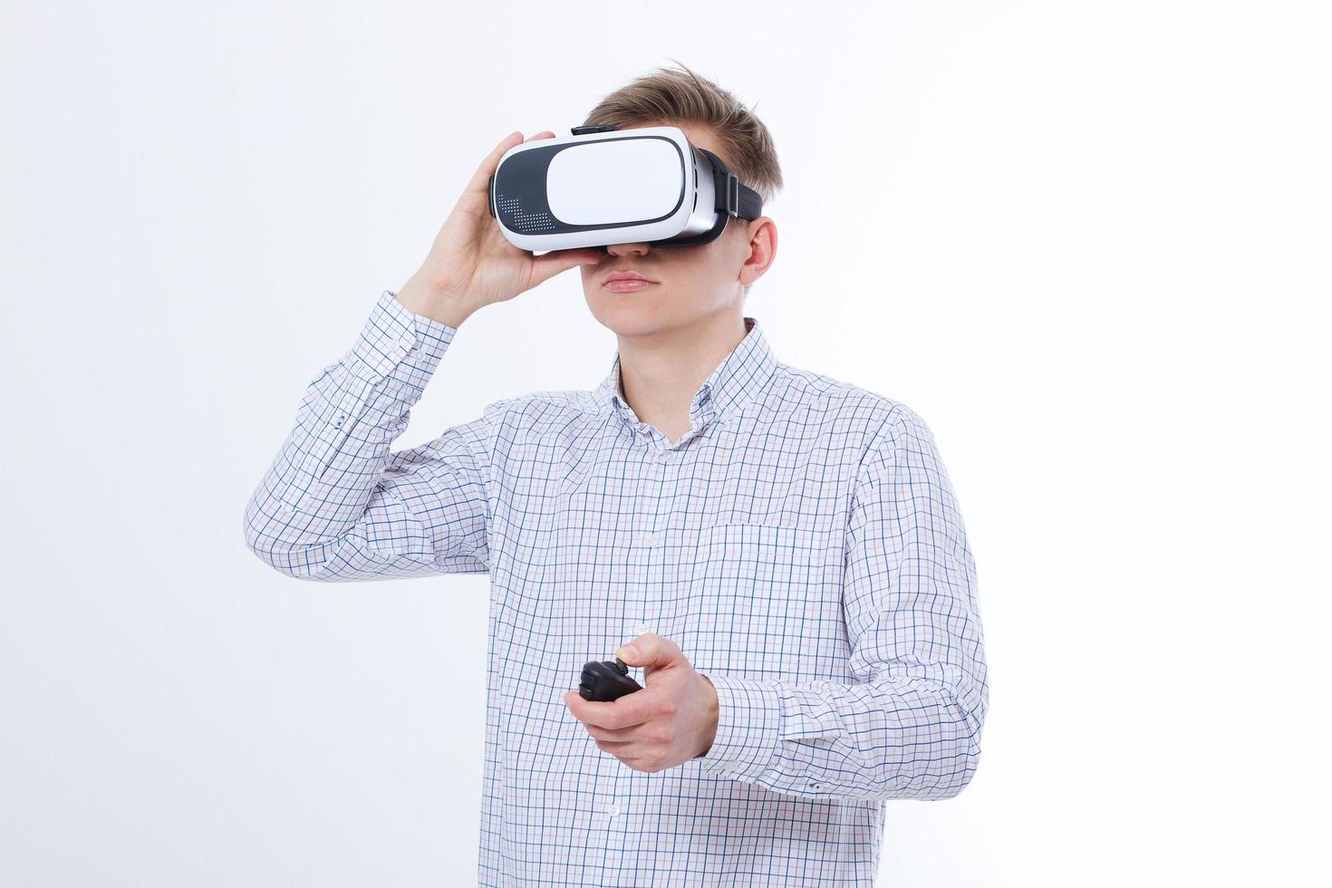 Young business man in vr glasses, goggles watching virtual reality isolated on white background. Copy space and mock up photo
