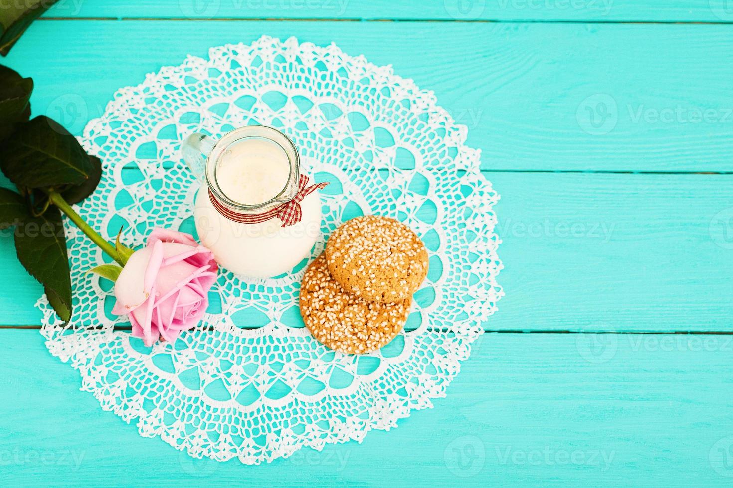 Brunch and pink rose on blue wooden background, lace napkin. Top view. Selective focus photo