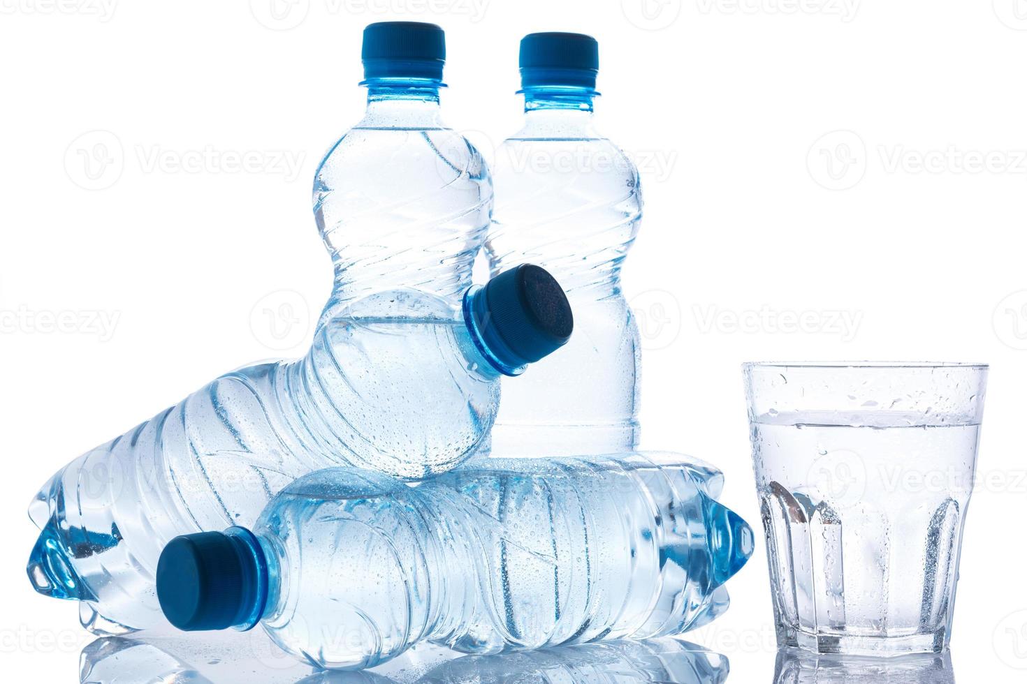 Glass and bottles with fresh water photo
