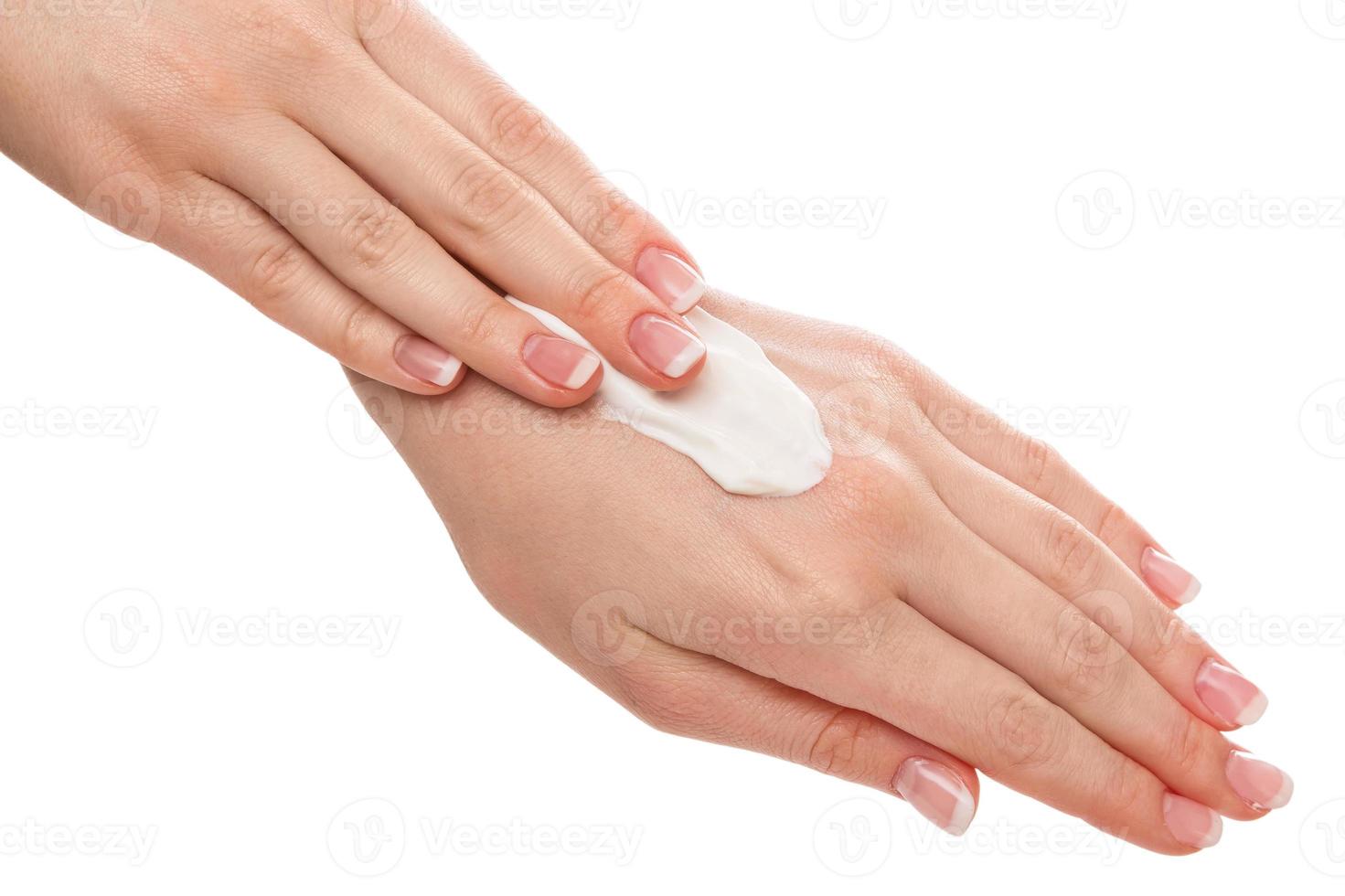 Woman applying moisturizer cream on hands photo