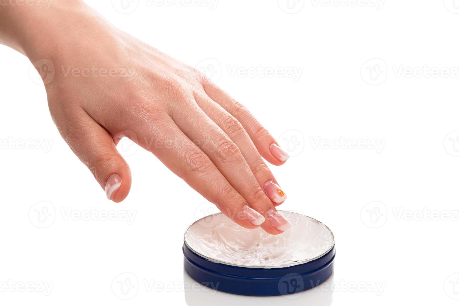 Woman applying moisturizer cream on hands photo