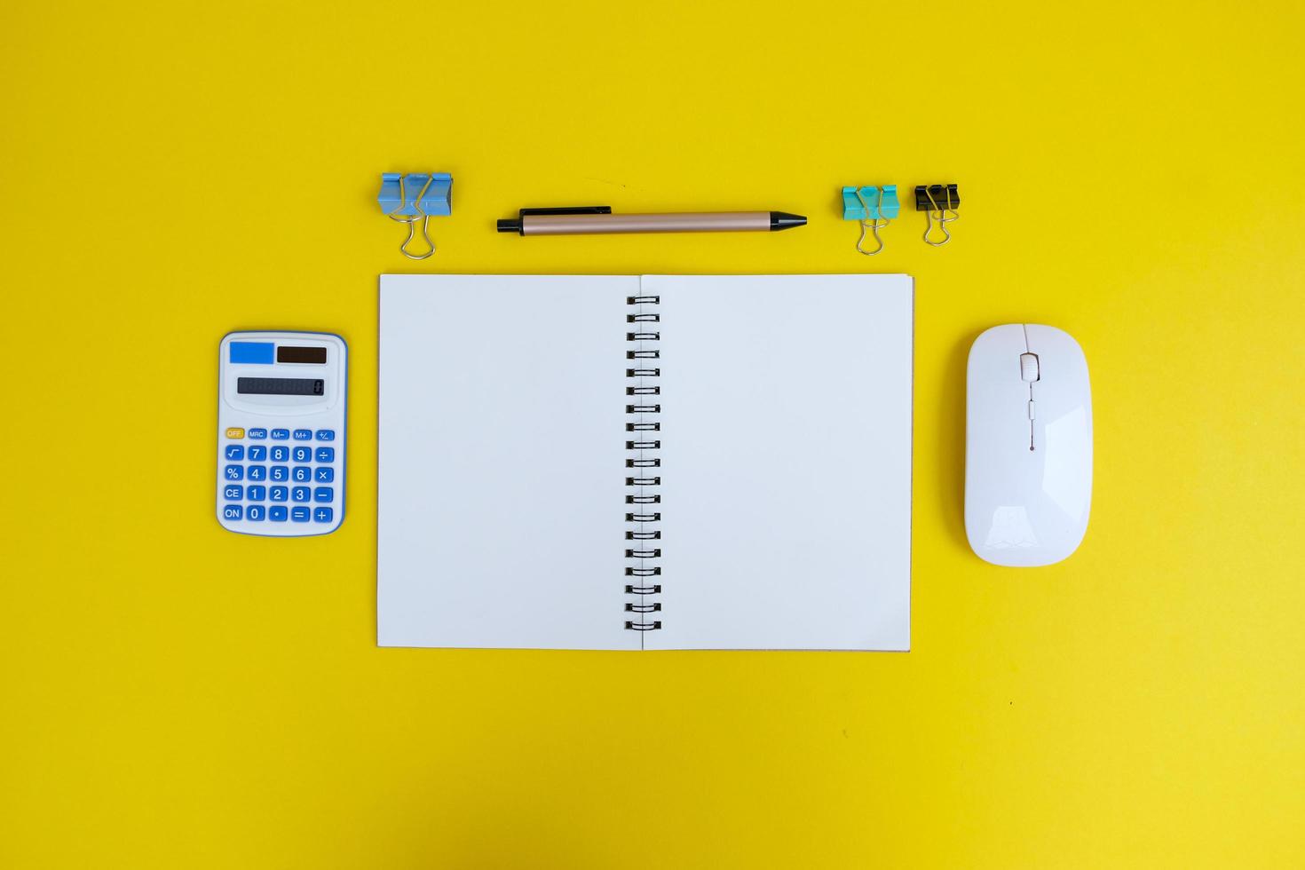 Blank notebook, a pen, and eyeglasses are on top of a white office desk table. Flat lay, top view. White designer office desk table with laptop, smartphone and supplies photo