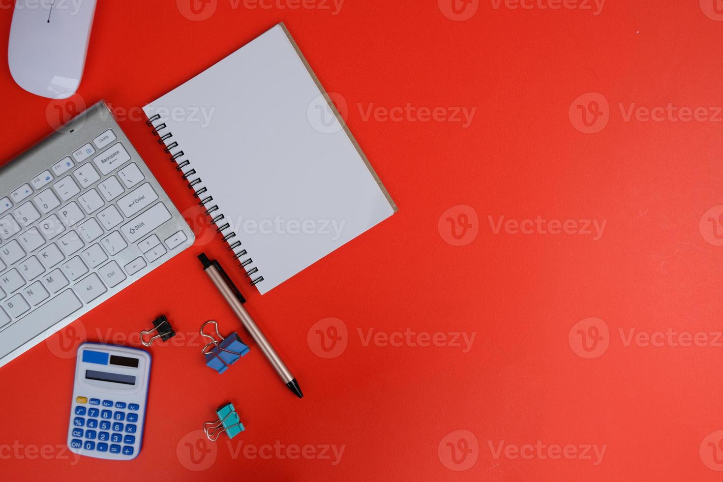 Blank notebook is in the middle of office desktable with pen and office supplies. Top view, flat lay. photo