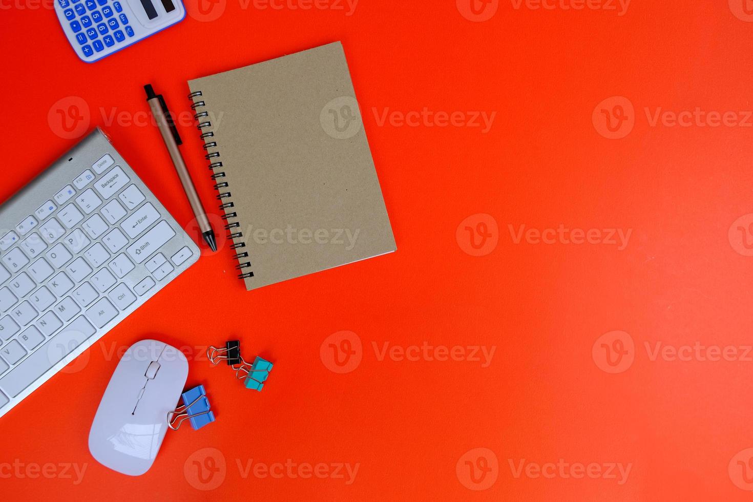 Blank notebook is in the middle of office desktable with pen and office supplies. Top view, flat lay. photo