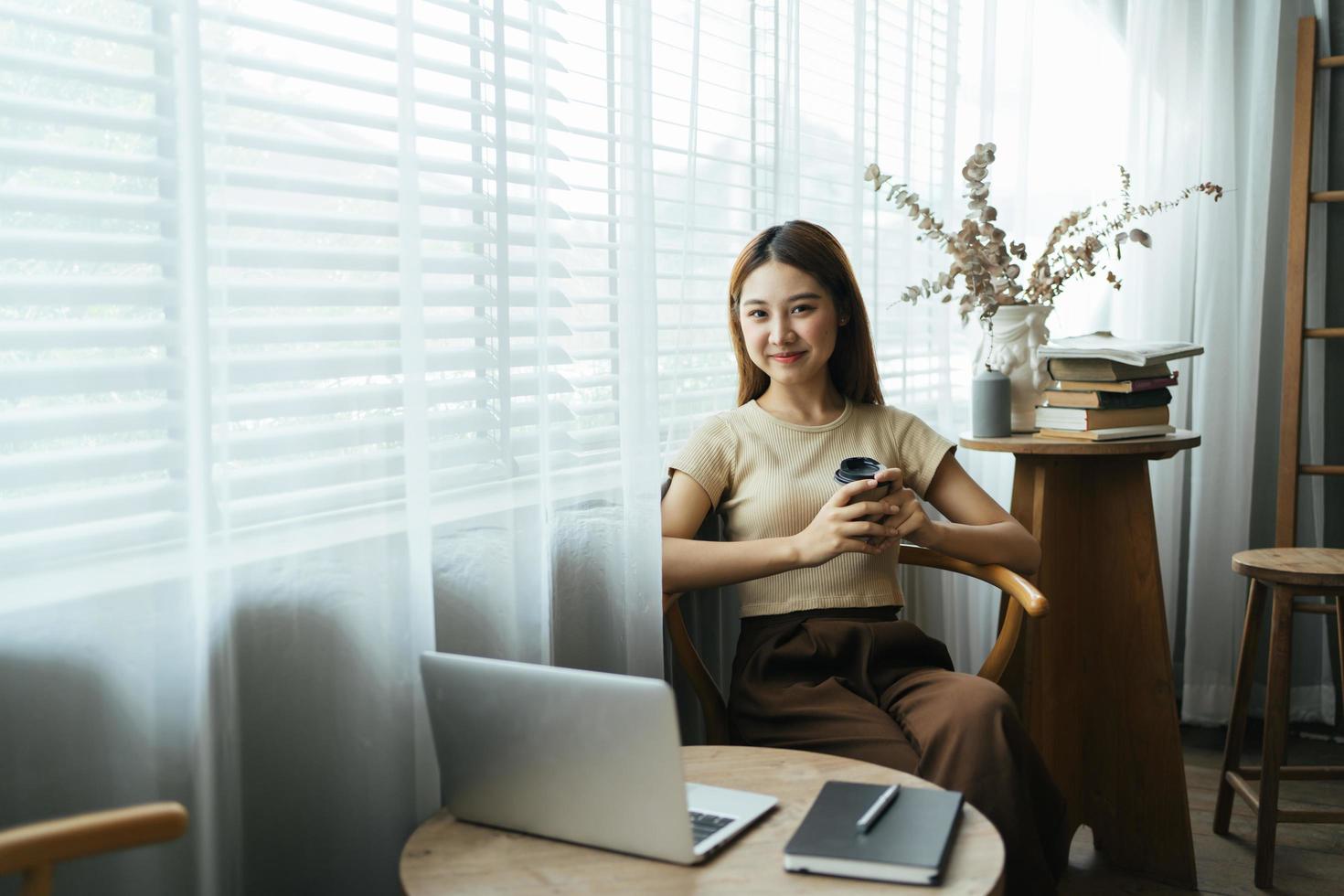 Portrait of Asian young female working on laptop and financial report at office. photo