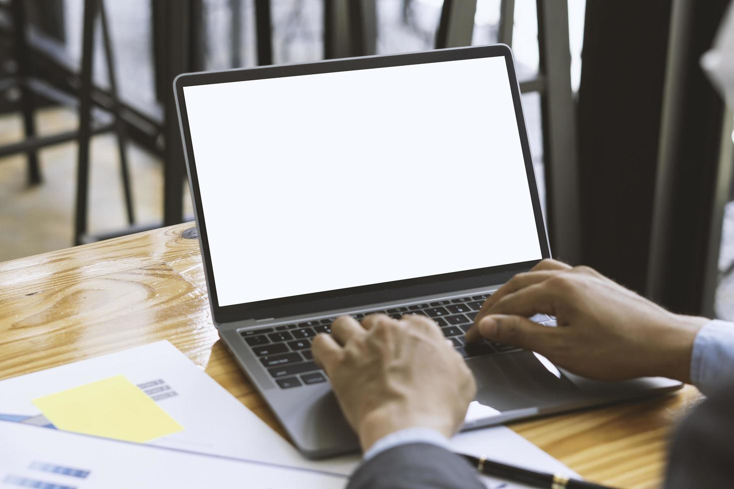 Side view of contemporary workplace with laptop computer, notebook, coffee cup and stationery on wooden table. clipping path. photo