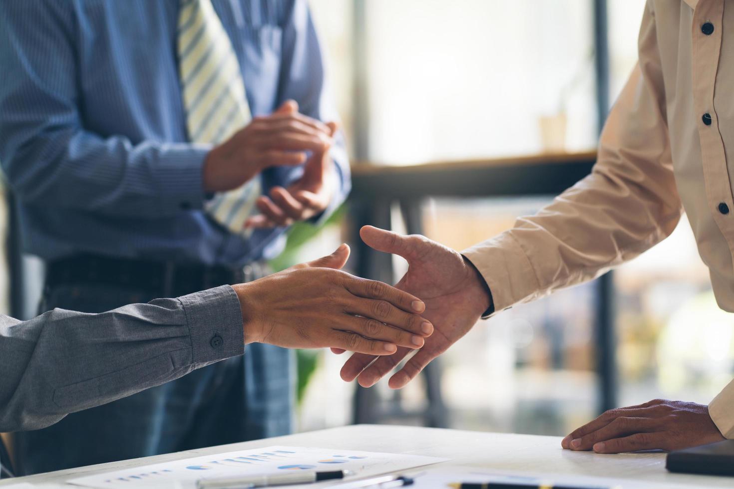 Closeup of male and female hands handshaking after effective negotiation showing mutual respect and intention for strong working relationships. Man in suit greeting female partner. Business concept photo