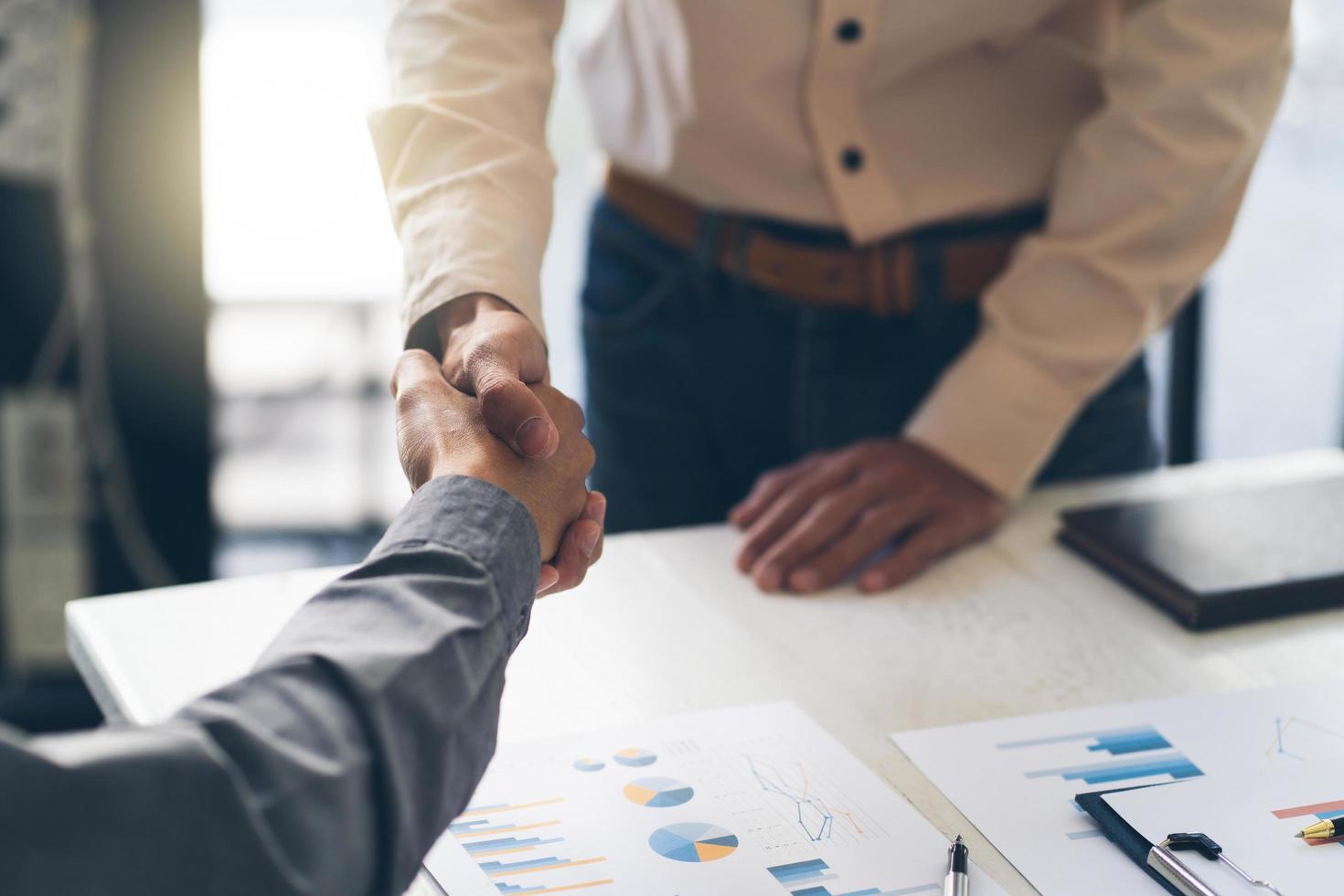 Closeup of male and female hands handshaking after effective negotiation showing mutual respect and intention for strong working relationships. Man in suit greeting female partner. Business concept photo