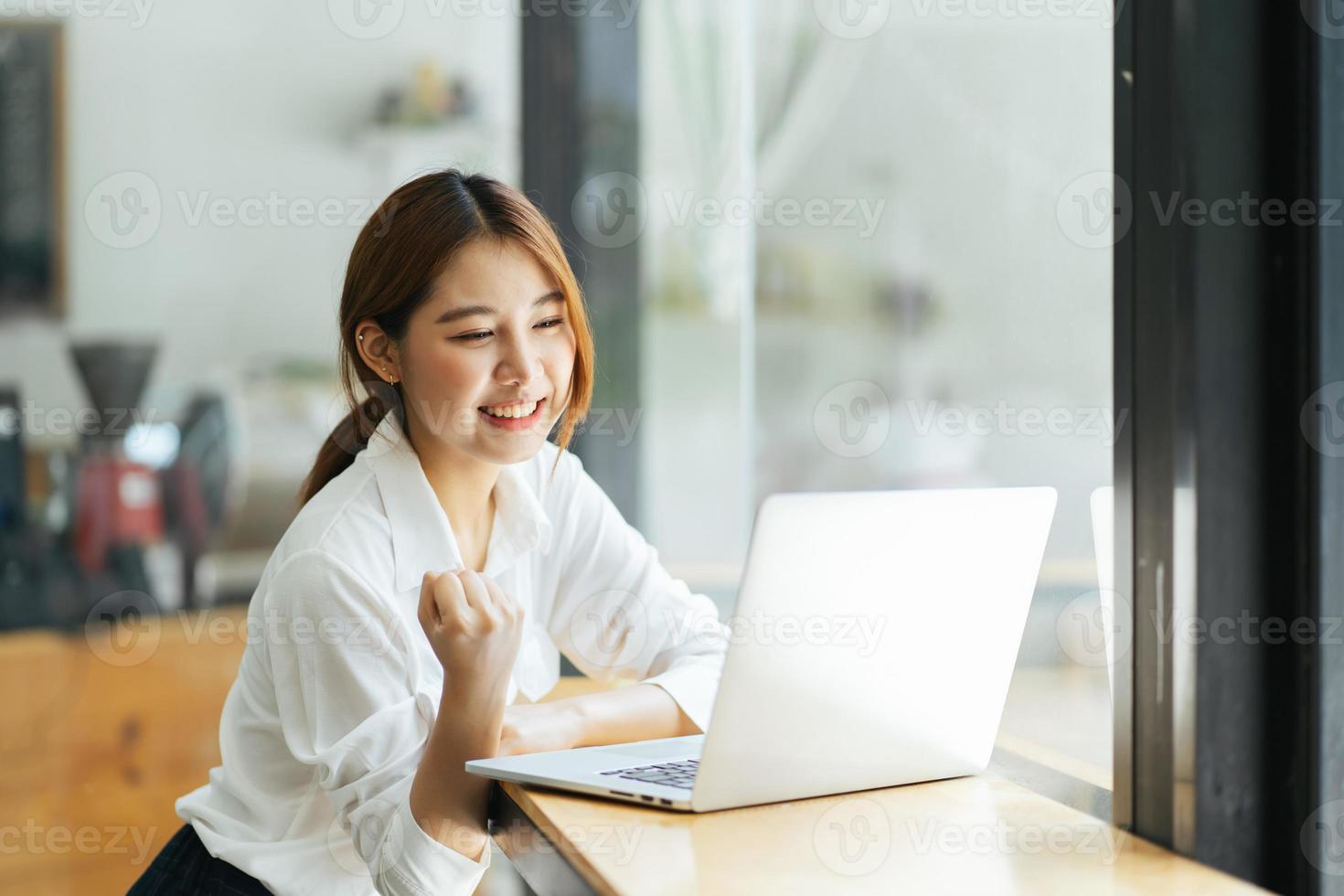 hermosa linda joven empresaria asiática en el café, usando computadora portátil. foto