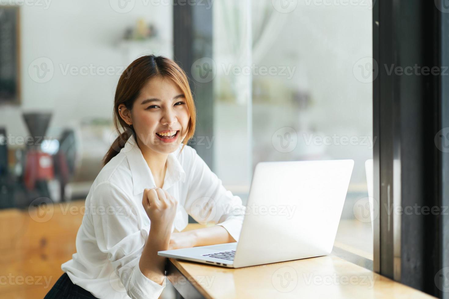 hermosa linda joven empresaria asiática en el café, usando computadora portátil. foto