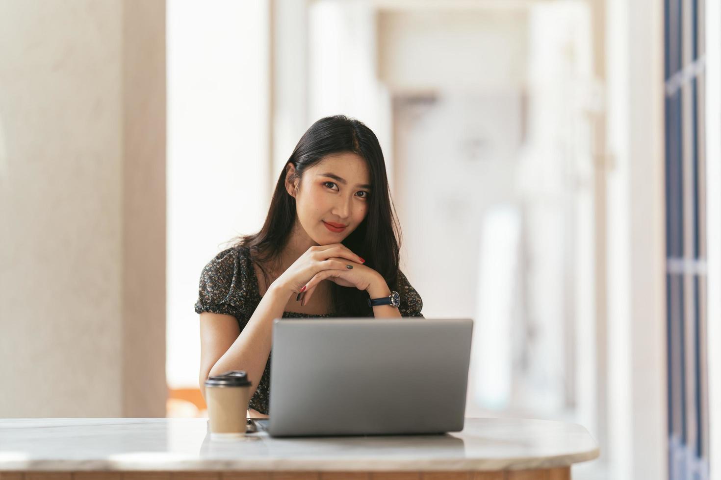 retrato de una joven asiática que trabaja en una laptop y un informe financiero en la oficina. foto