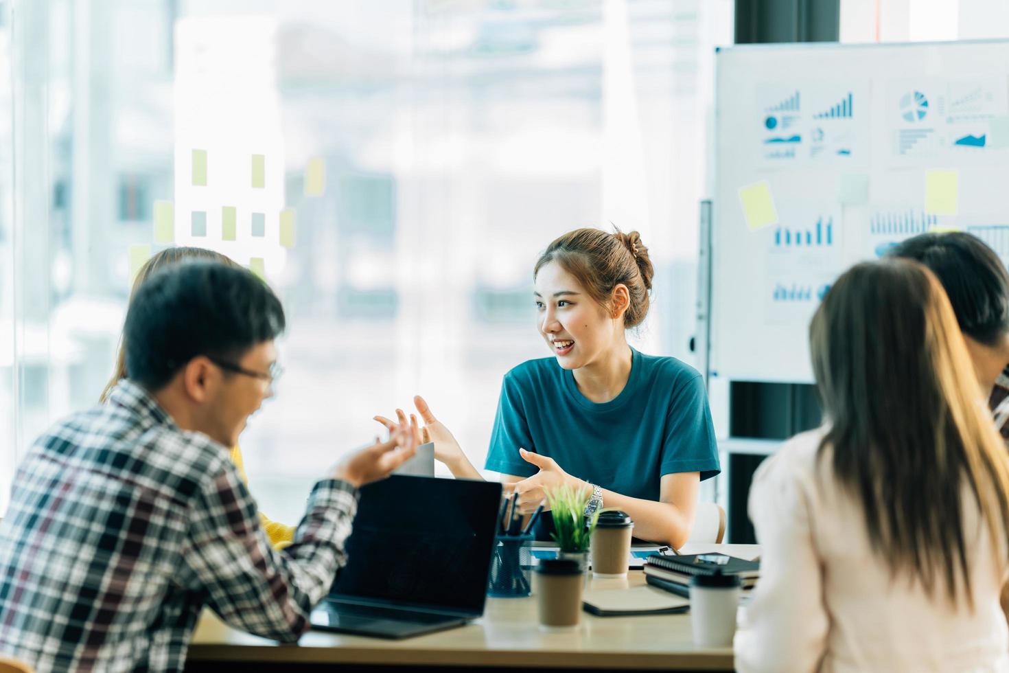 joven mujer asiática líder del equipo creativo de negocios en el proyecto de diseño de software de aplicaciones móviles. reunión de lluvia de ideas, trabajar juntos, tecnología de Internet, poder femenino, concepto de trabajo en equipo de compañeros de oficina foto