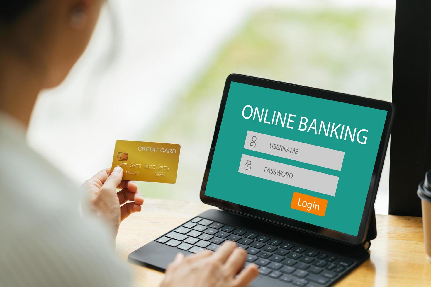 smiling woman paying online, using laptop, holding plastic credit card, sitting on coffee shop, Asian female shopping, making secure internet payment, browsing banking service. photo