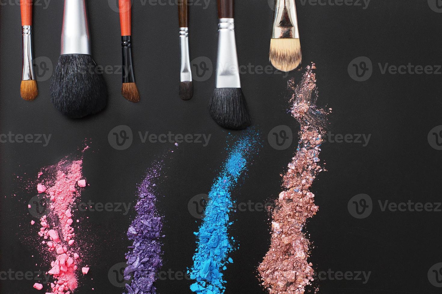 Eyeshadows and make up brushes on black background. Summer fashion style. Copy space photo