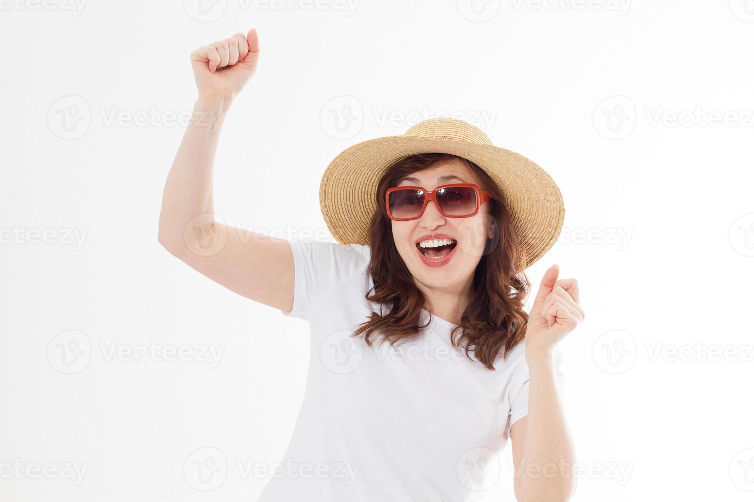 Happy surprised and excited woman in summer hat, sunglasses and template white t shirt isolated on white background. Holiday vacation with big sale. Fun summertime. Copy space, blank place on tshirt. photo