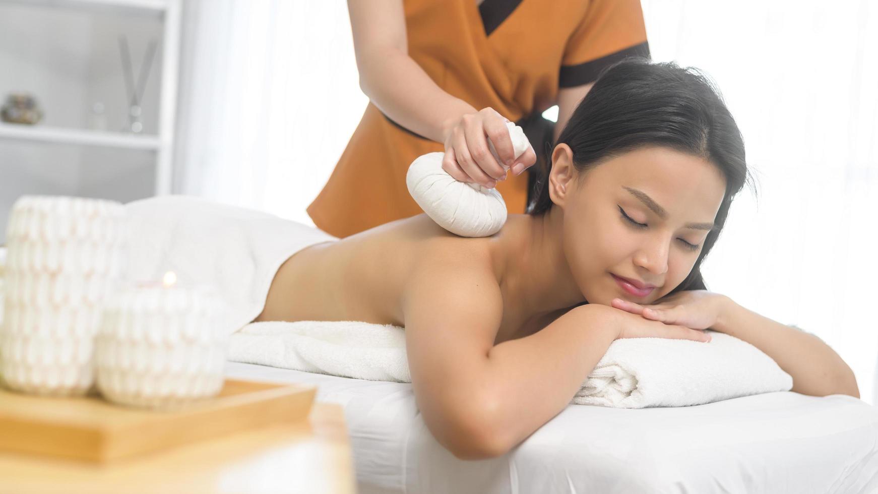 Young asian beautiful woman relaxing and enjoying massage, spa and beauty treatment concept photo