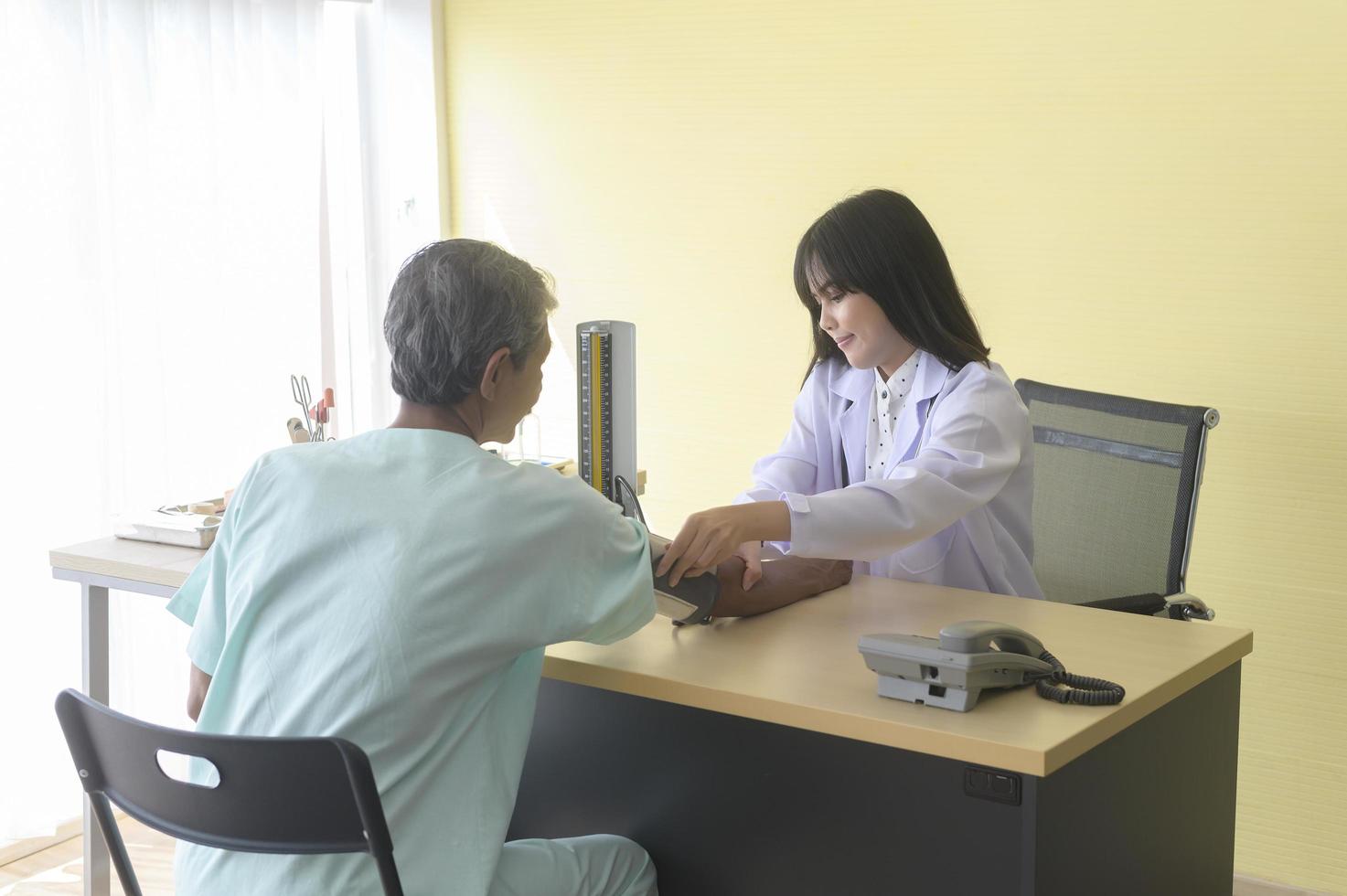 El paciente masculino asiático mayor está consultando y visitando al médico en el hospital. foto